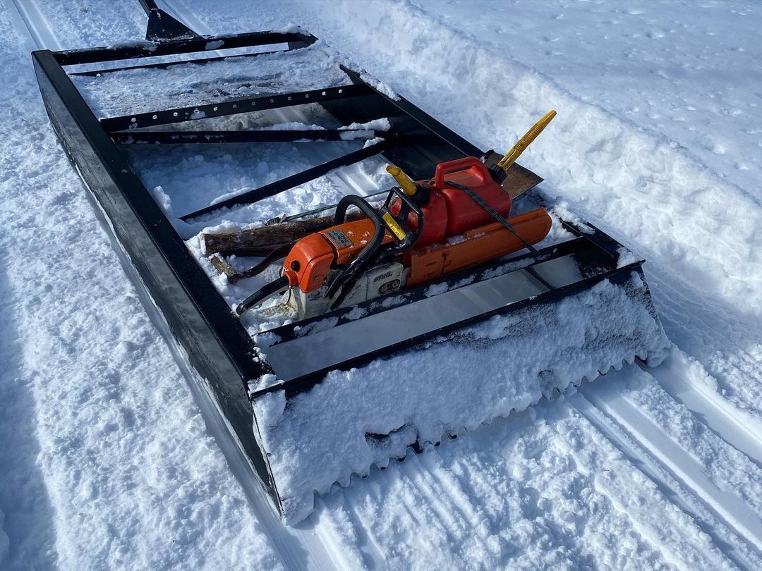 A chainsaw is sitting on top of a homestead legacy trail groomer