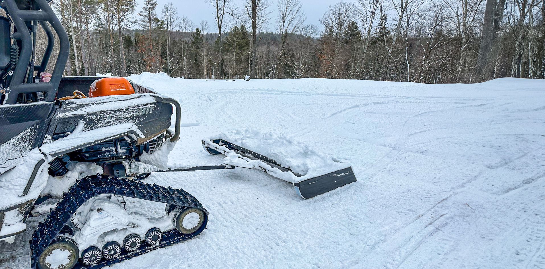 A snow plow pulling a 60 inch trail groomer