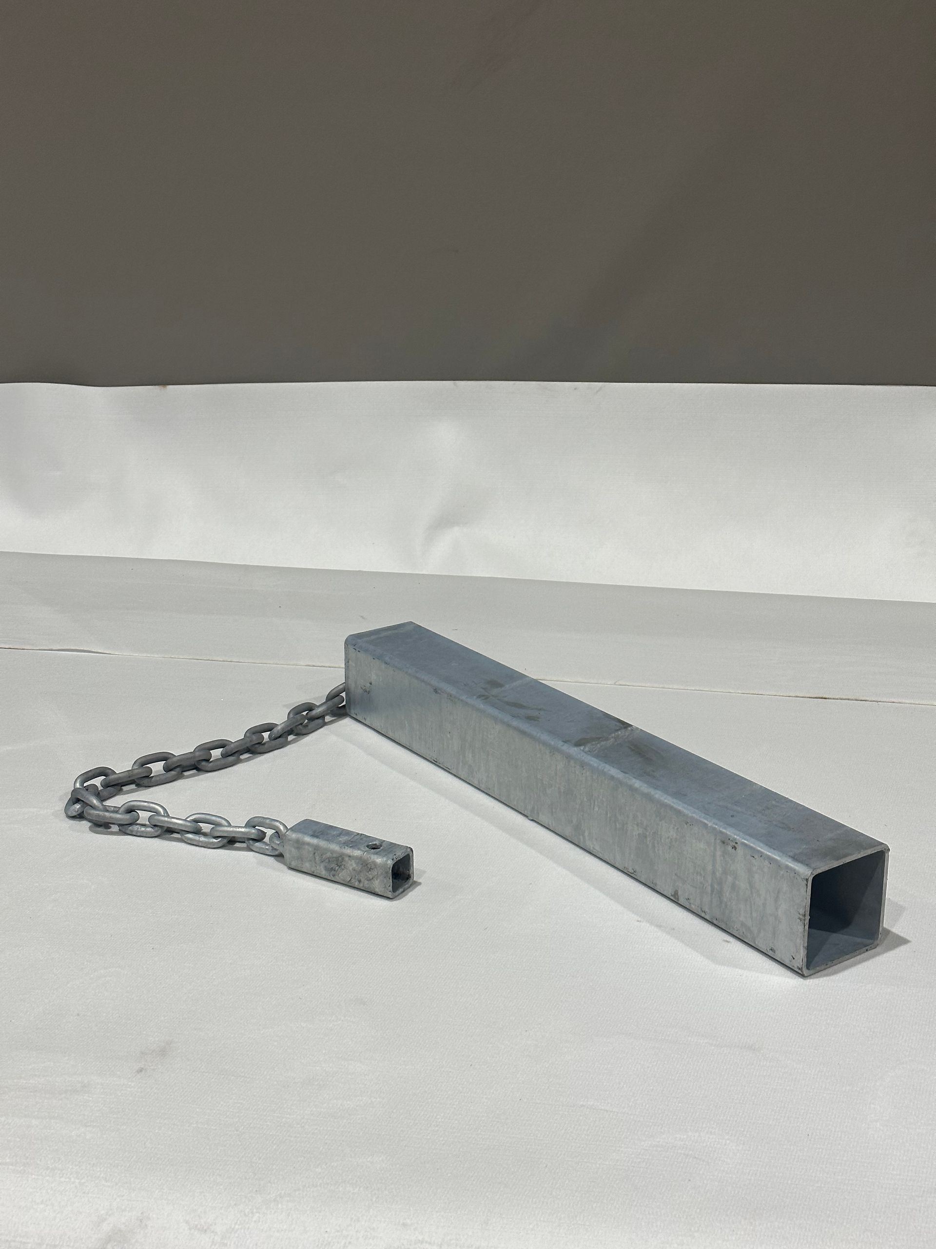 A metal bar with a chain attached to it is sitting on a table.