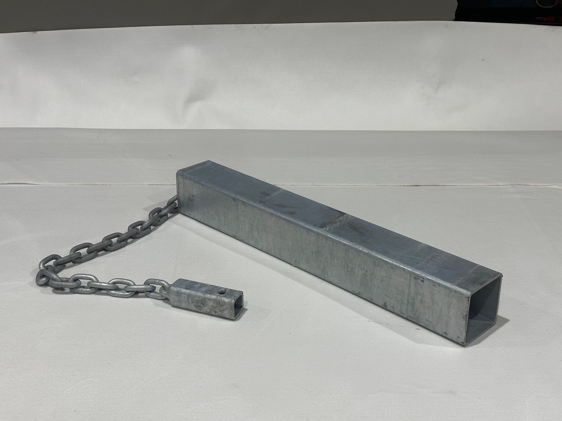 A metal bar with a chain attached to it is sitting on a table.
