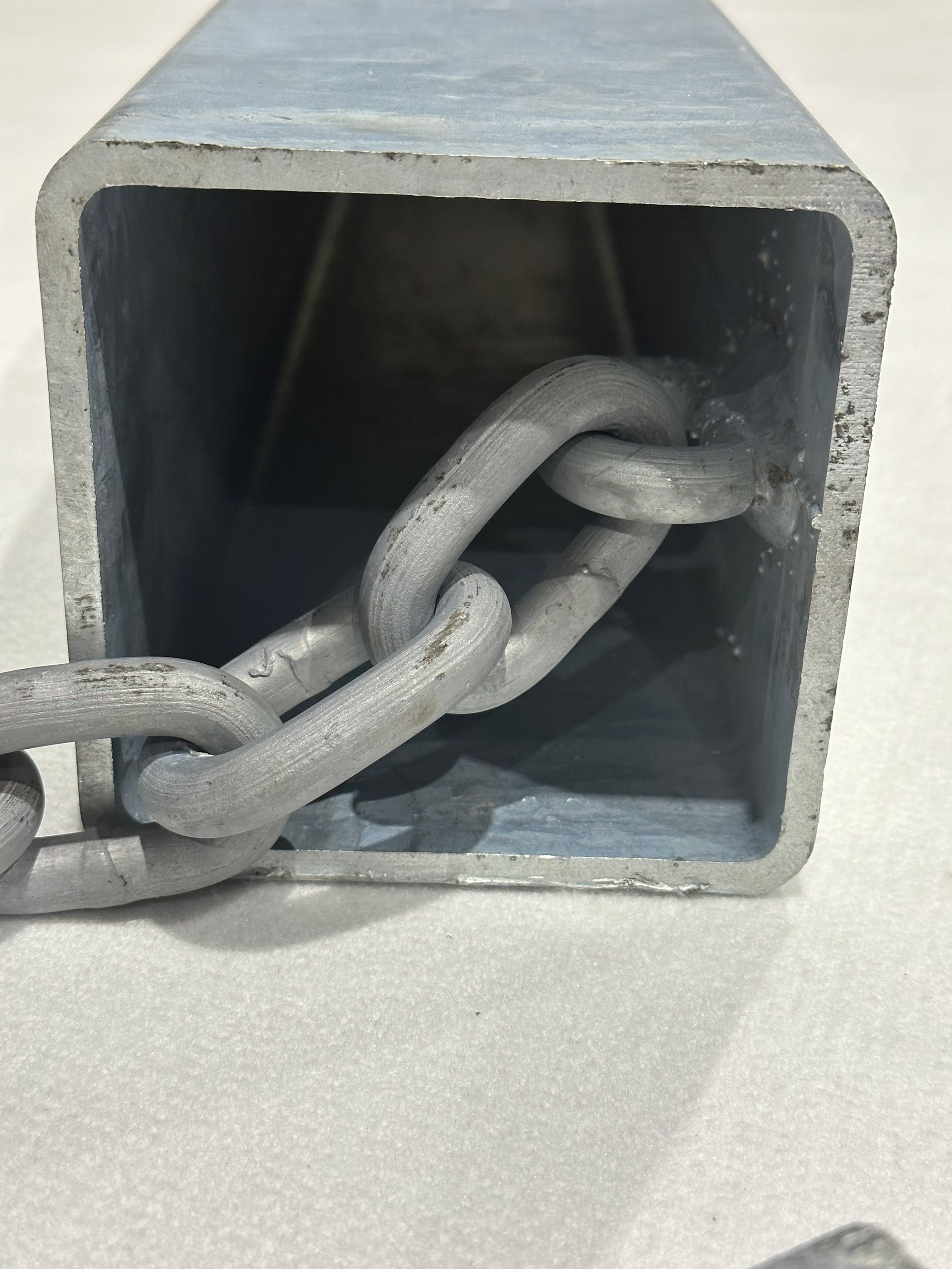 A metal square with a chain attached to it