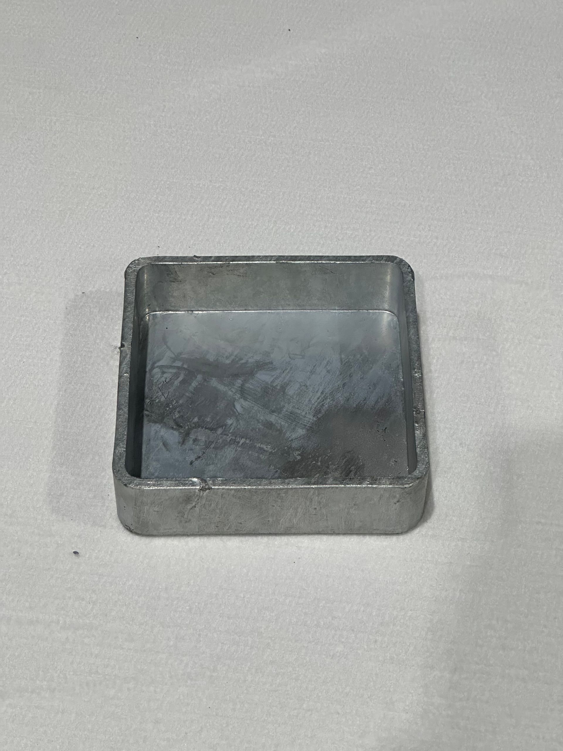 A small square metal tray is sitting on a table.