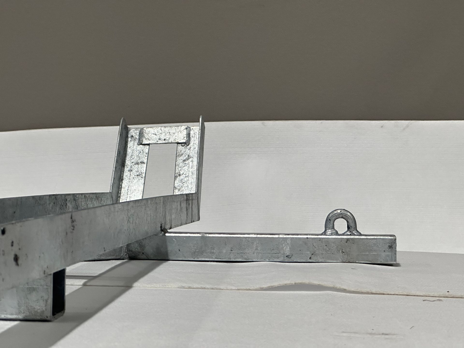 A piece of metal is sitting on a white surface.