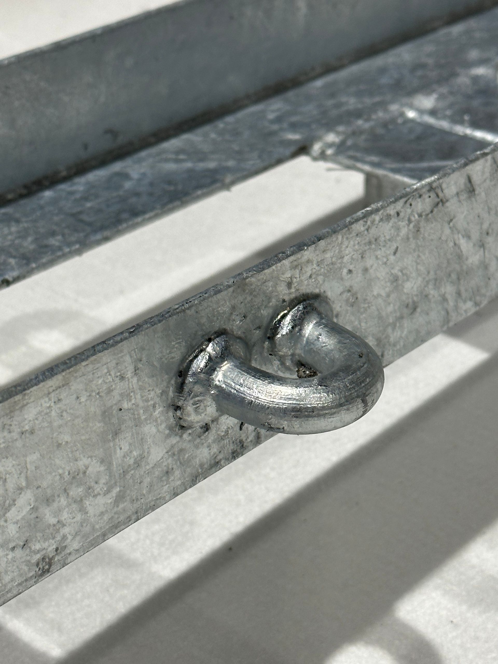 A close up of a metal object with a hook on it