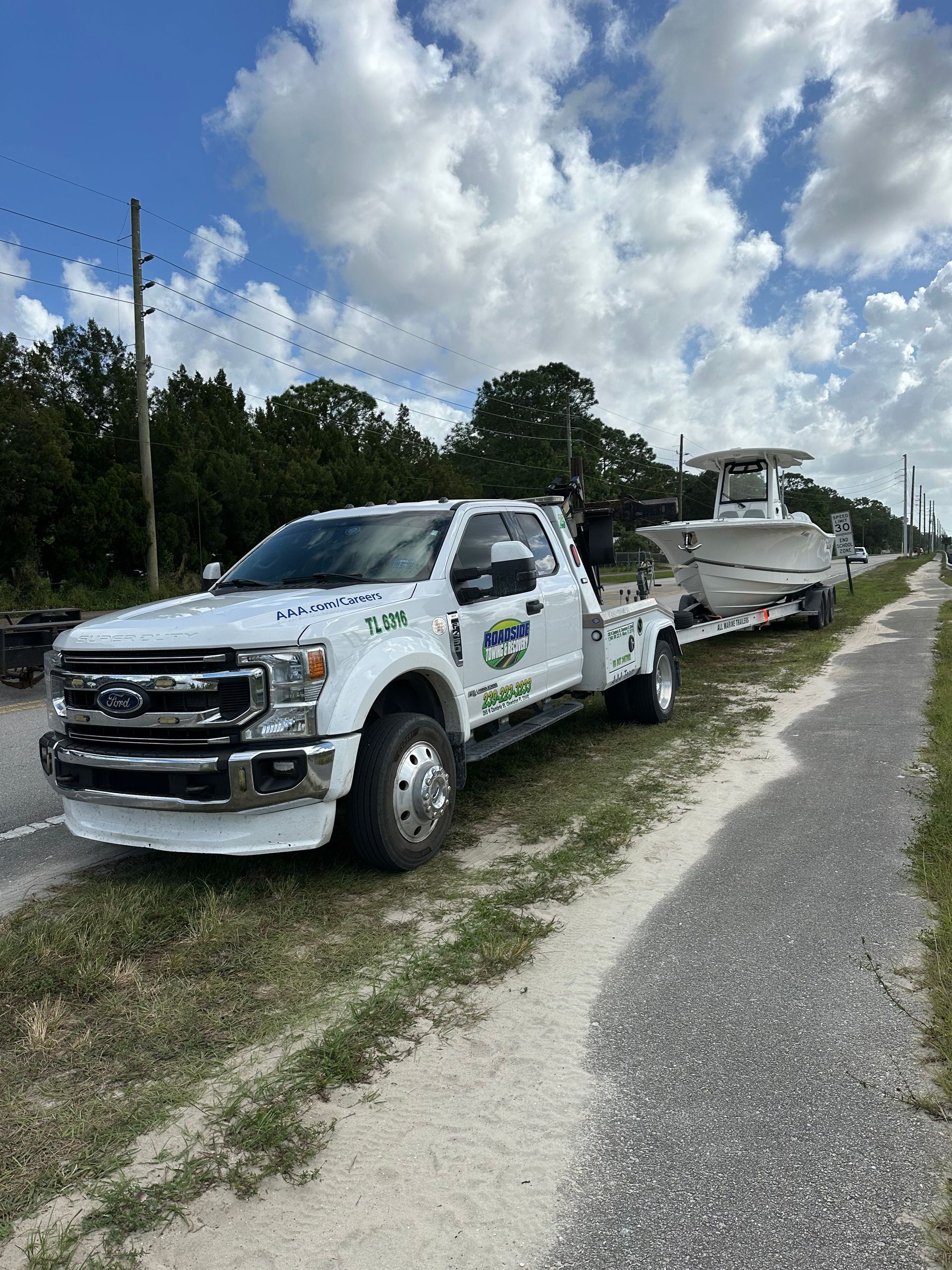 Center console boat towing in Miami-Dade – roadside boat transport with heavy-duty Ford tow truck.