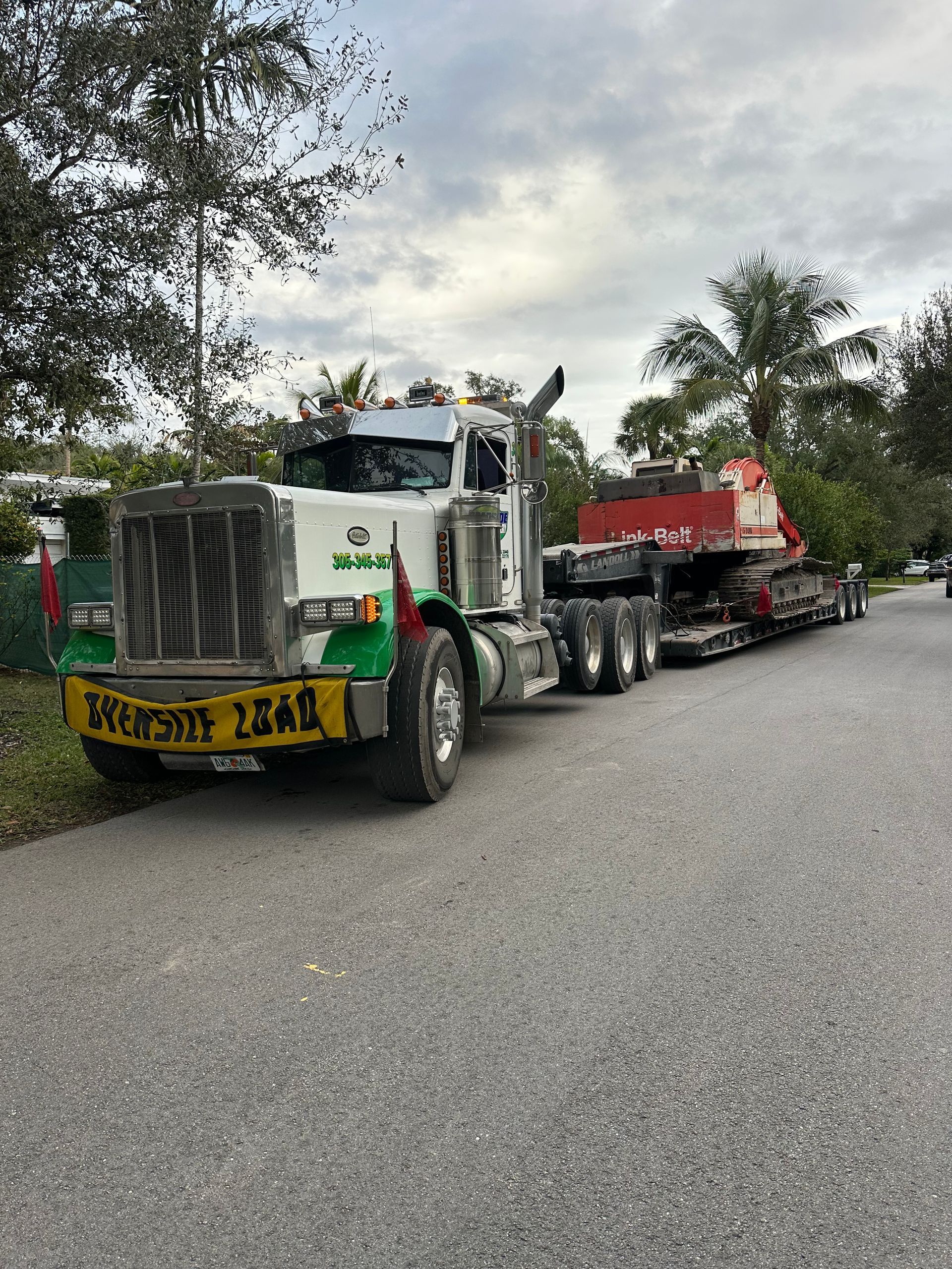 Oversized load hauling in Miami-Dade – Link-Belt excavator transport on Landoll trailer with heavy-duty Peterbilt truck.