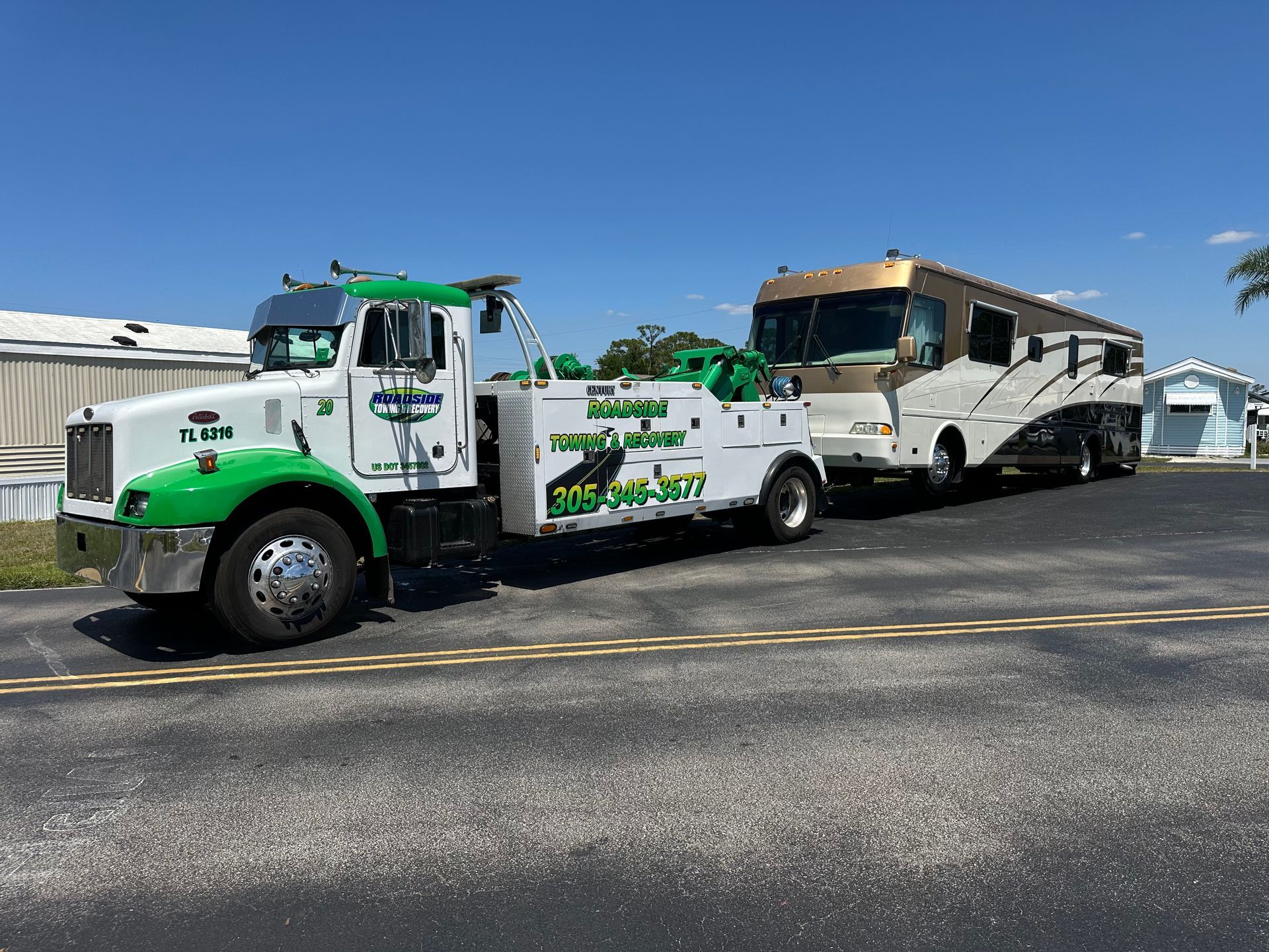 RV towing service in Miami-Dade – heavy-duty tow truck from Roadside Towing and Recovery transporting a luxury motorhome.