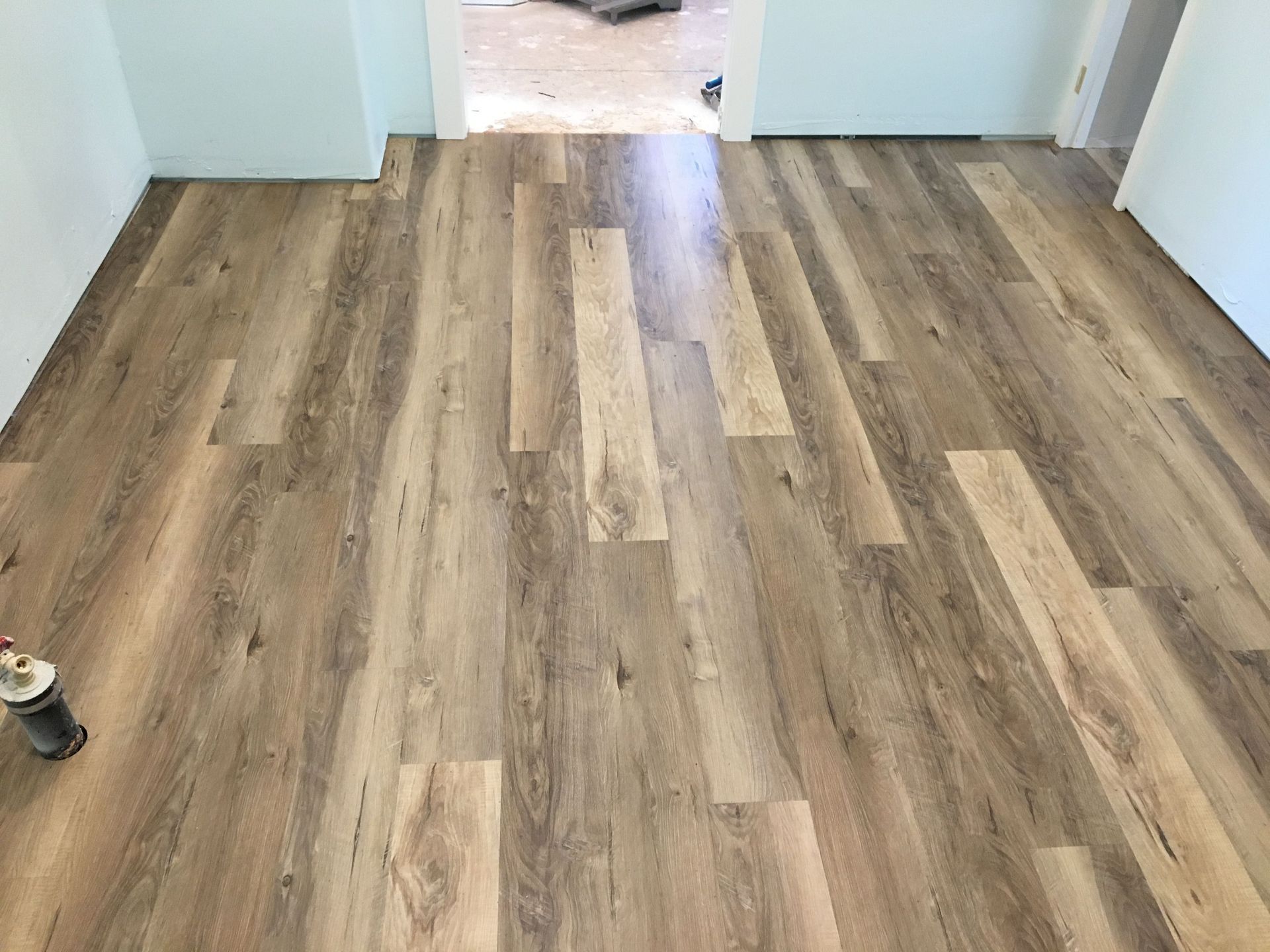 Worker using a cutter to carefully install new carpet flooring in a room, ensuring precise measurements and smooth placement.