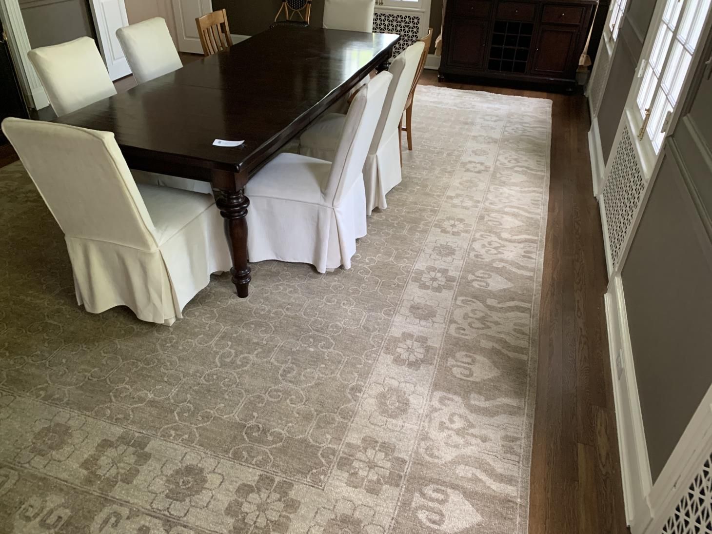 Worker using a cutter to carefully install new carpet flooring in a room, ensuring precise measurements and smooth placement.