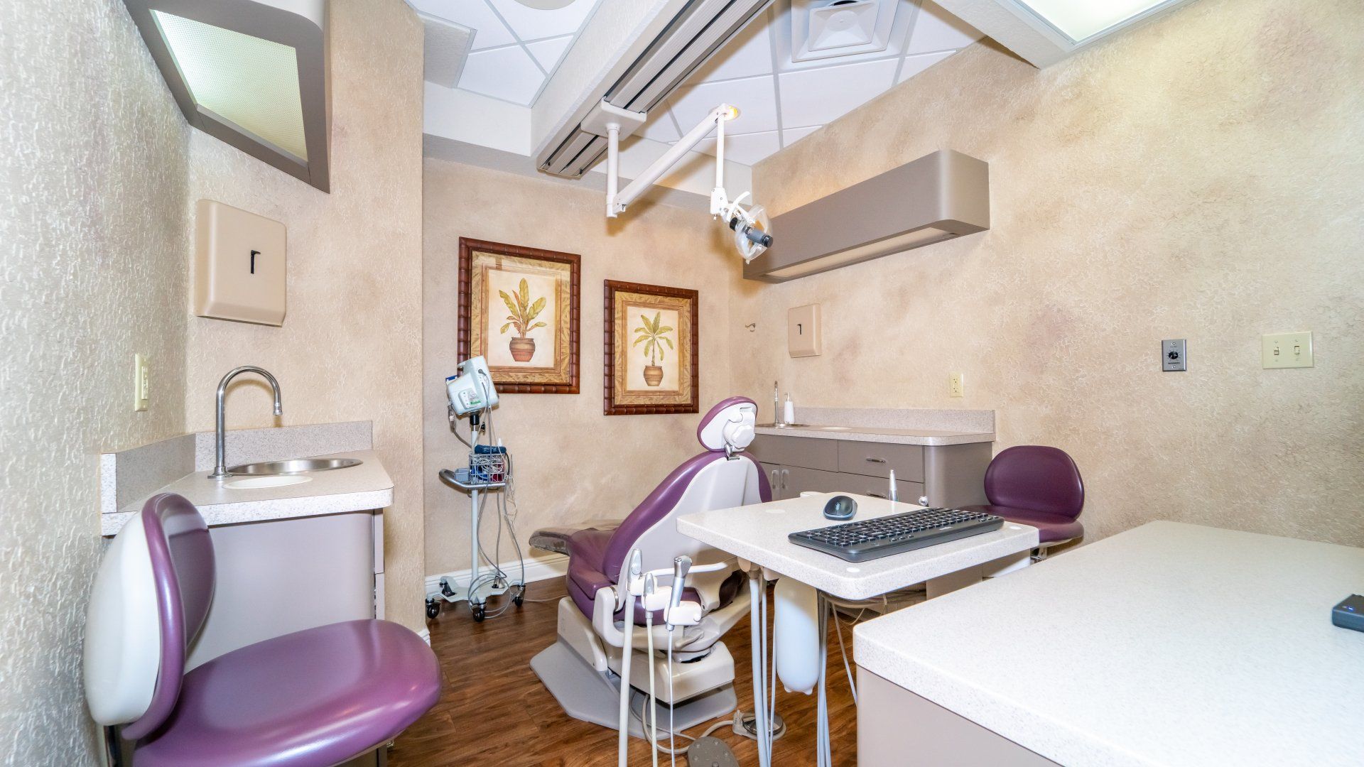 A dental office with a purple chair and a white desk.