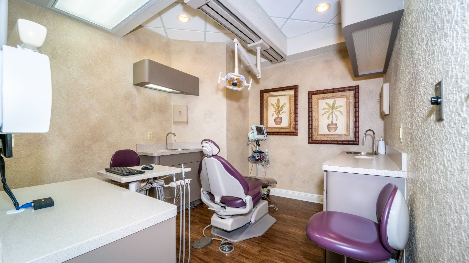 A dental office with a purple chair and a table.