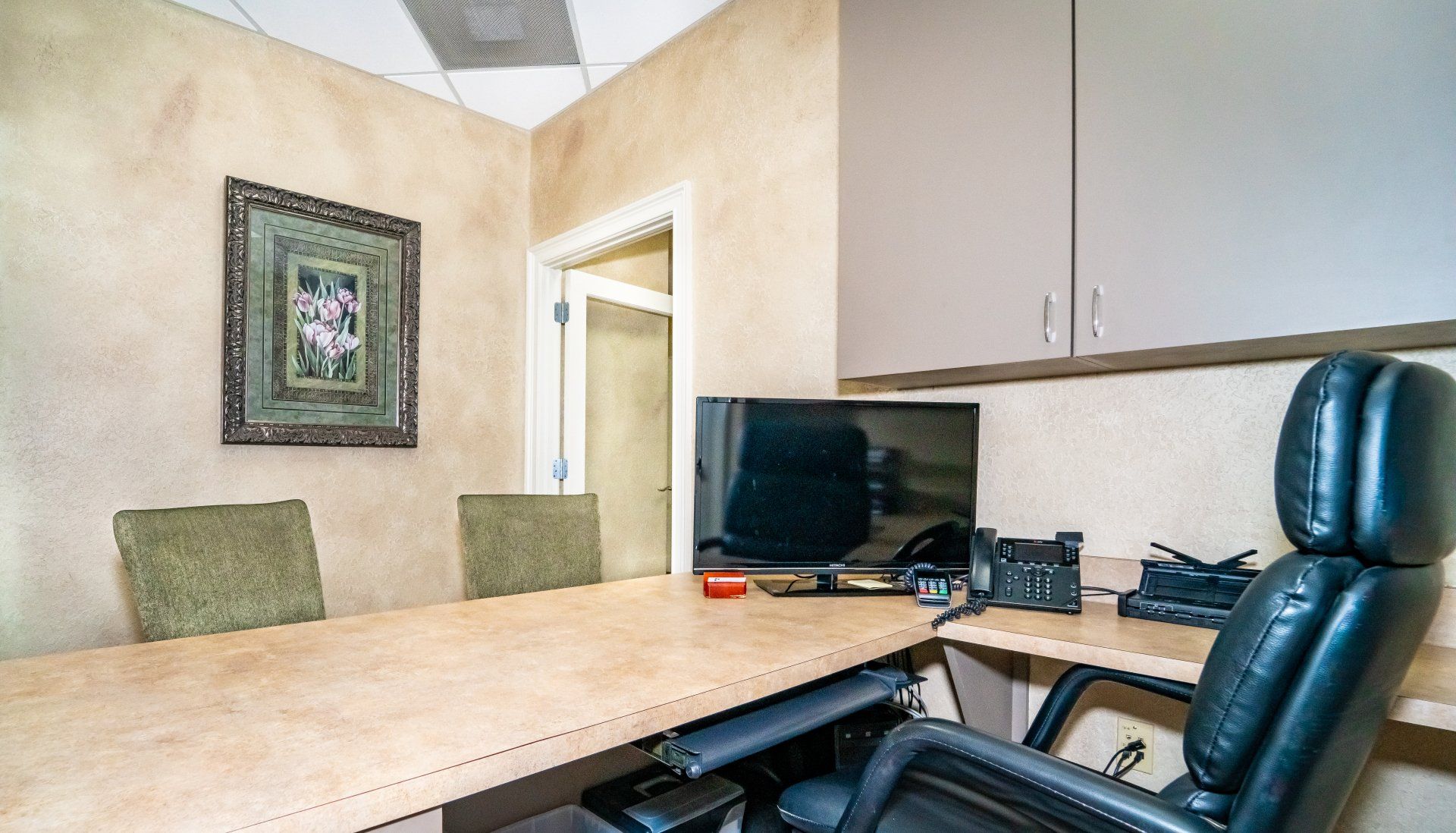 A conference room with a table and chairs and a computer on it.