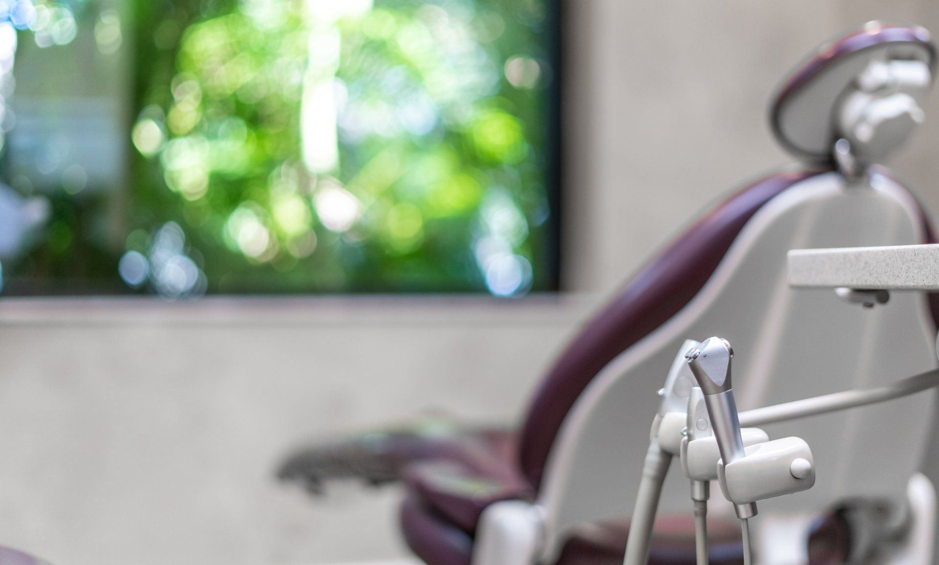 A dental chair in a dental office with a window in the background.