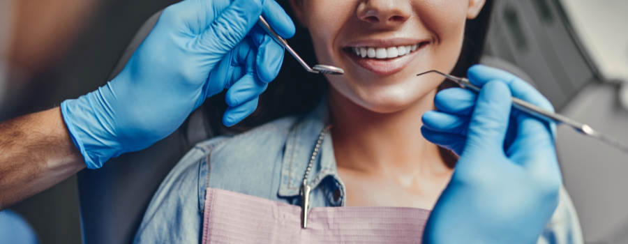 A woman is getting her teeth examined by a dentist.