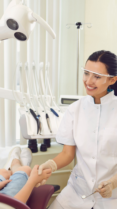 A dentist is examining a patient 's teeth in a dental studio.