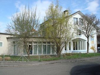 Man sieht das Dr. Augustin Haus. ein weisses, helles Gebäude.