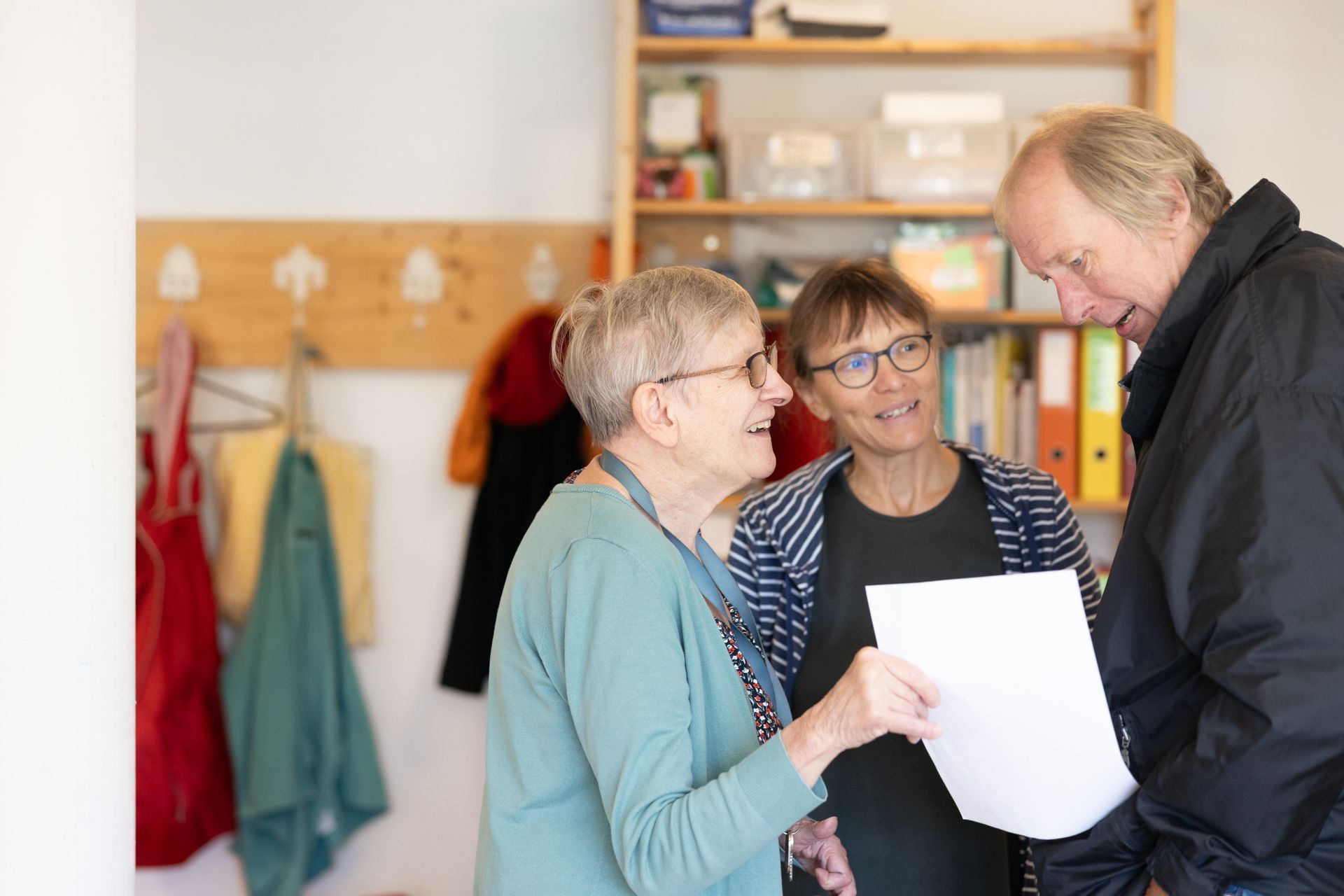 Eine Frau in weissem Hemd hält ein kleines Mädchen im Arm