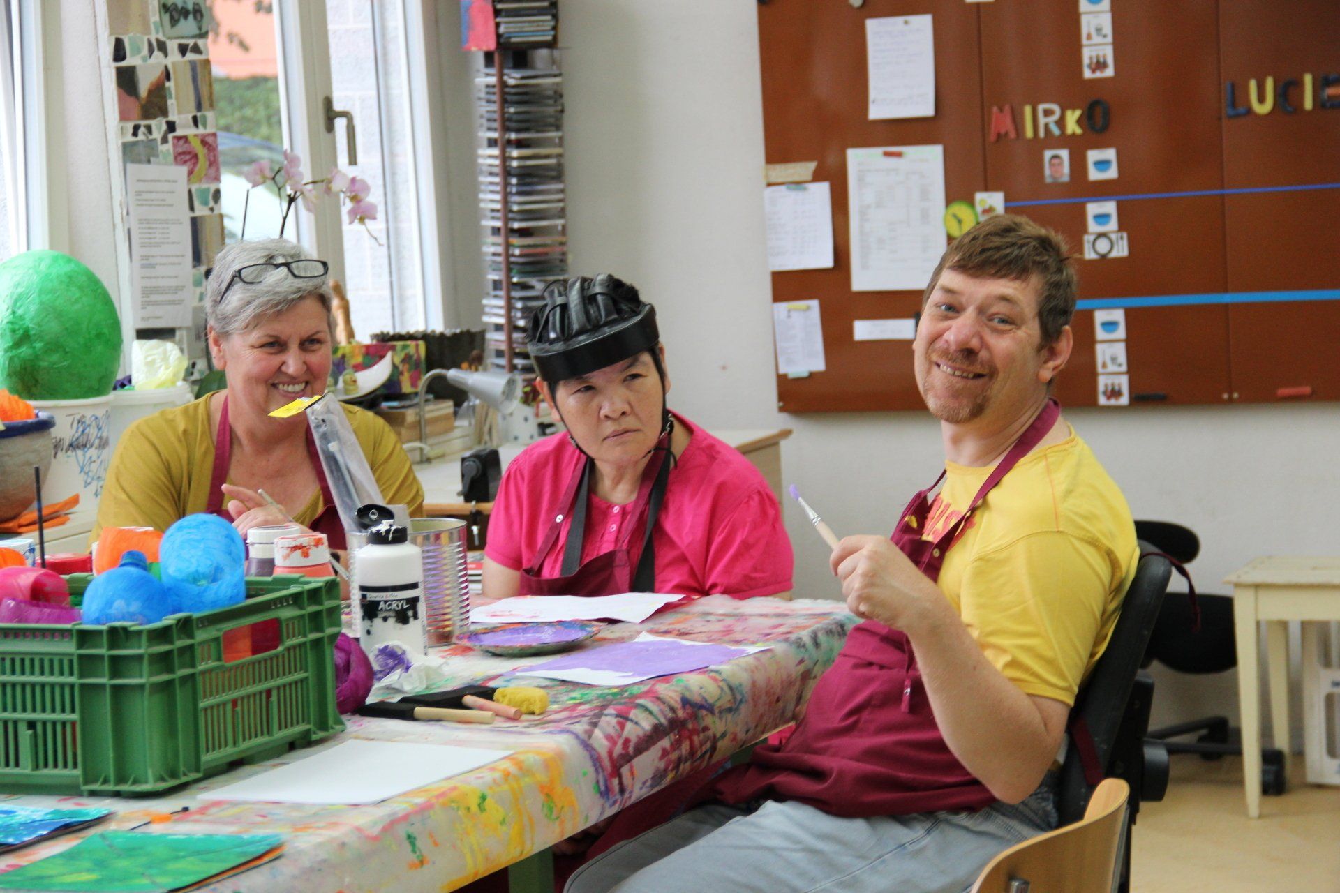 Eine Frau sitzt an einem Tisch vor Regalen voller Kleidung