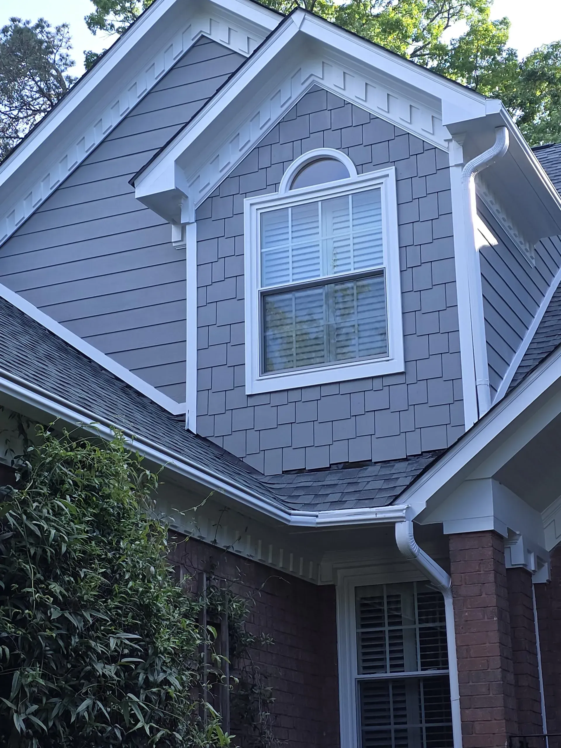 House exterior with grey siding, white trim, and a window.