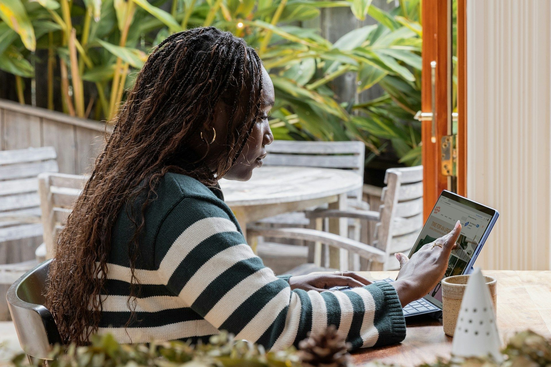 A woman is sitting at a table using a laptop computer.