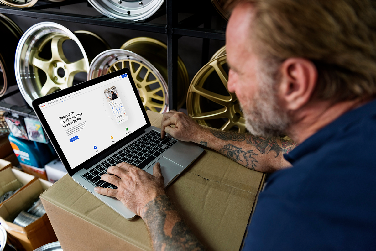 Image of an auto repair shop owner looking at the Google Business Profile website on his laptop