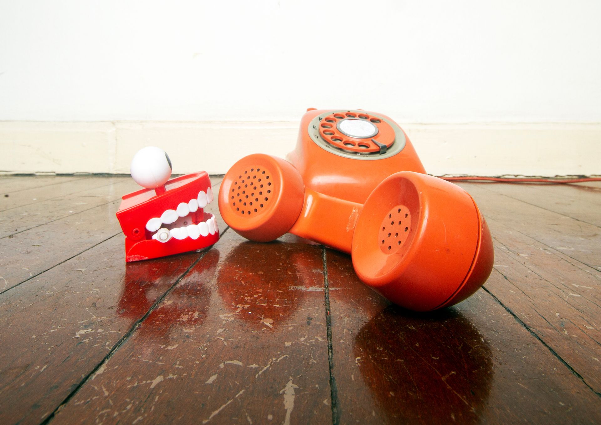 Robo and spam call image concept with a chattering teeth toy talking into a phone receiver.