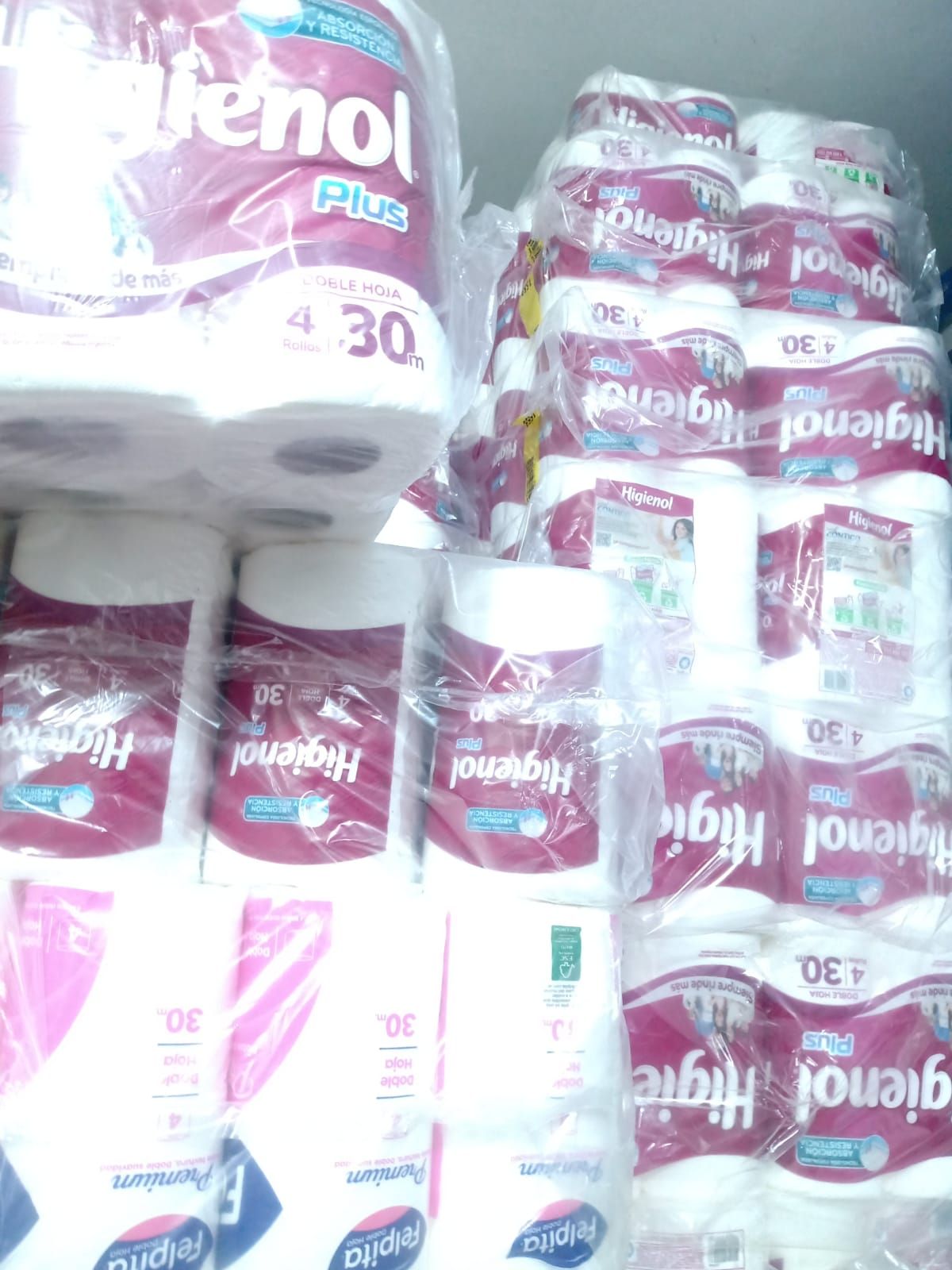 Varios paquetes de papel higiénico Higieno Plus apilados.