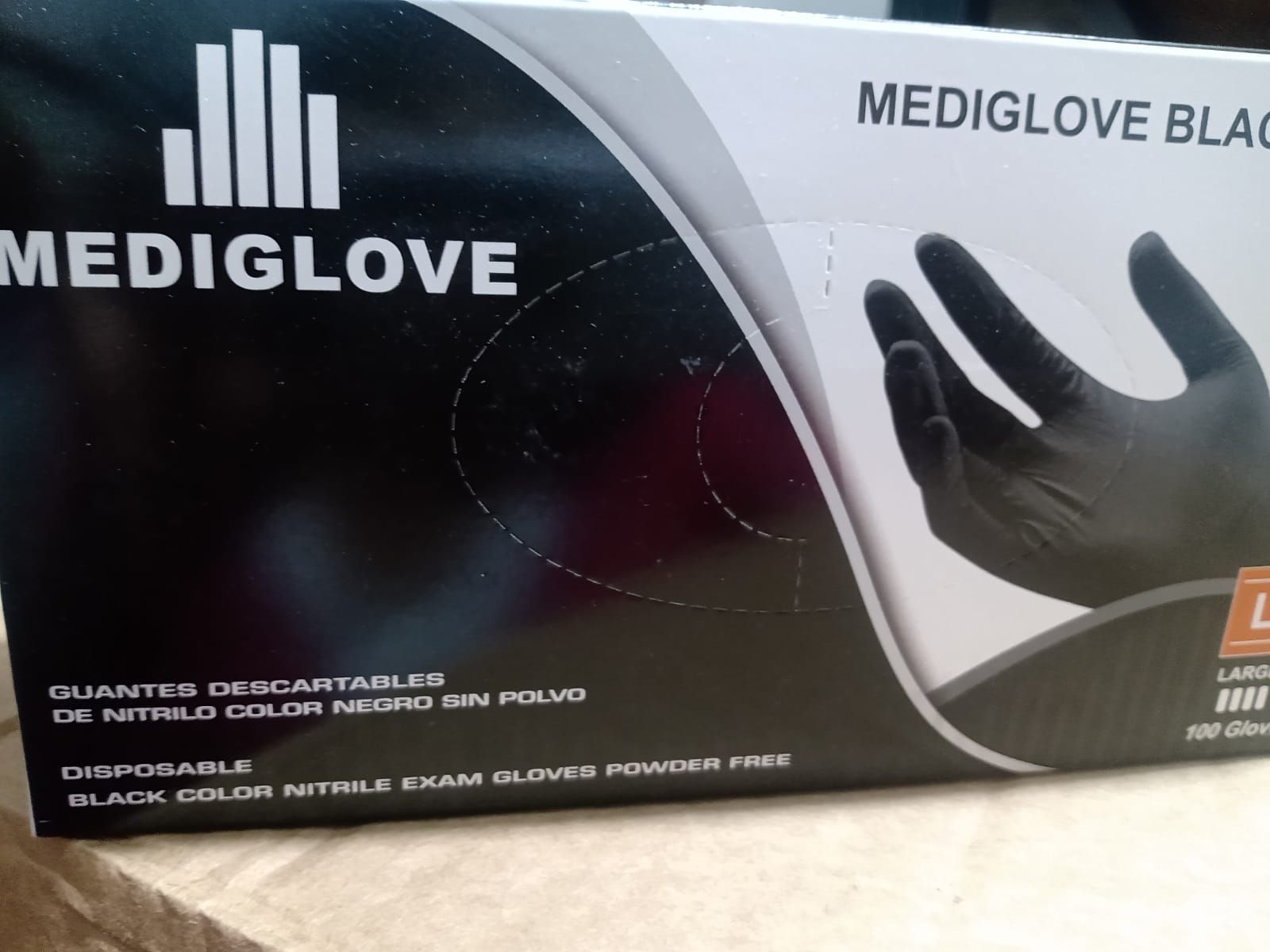 Una caja de guantes desechables de nitrilo negro sin polvo Mediglove para examen, talla grande, que contiene 100 guantes.