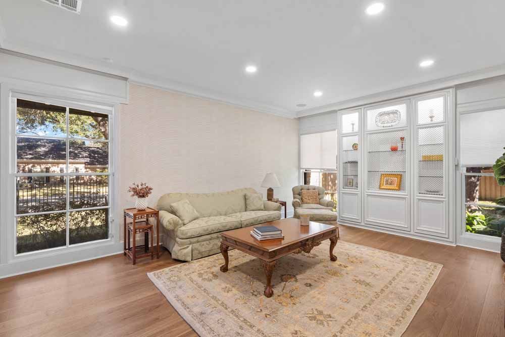 Living room with sofa, chair, coffee table, rug, built-in shelves, and large window.