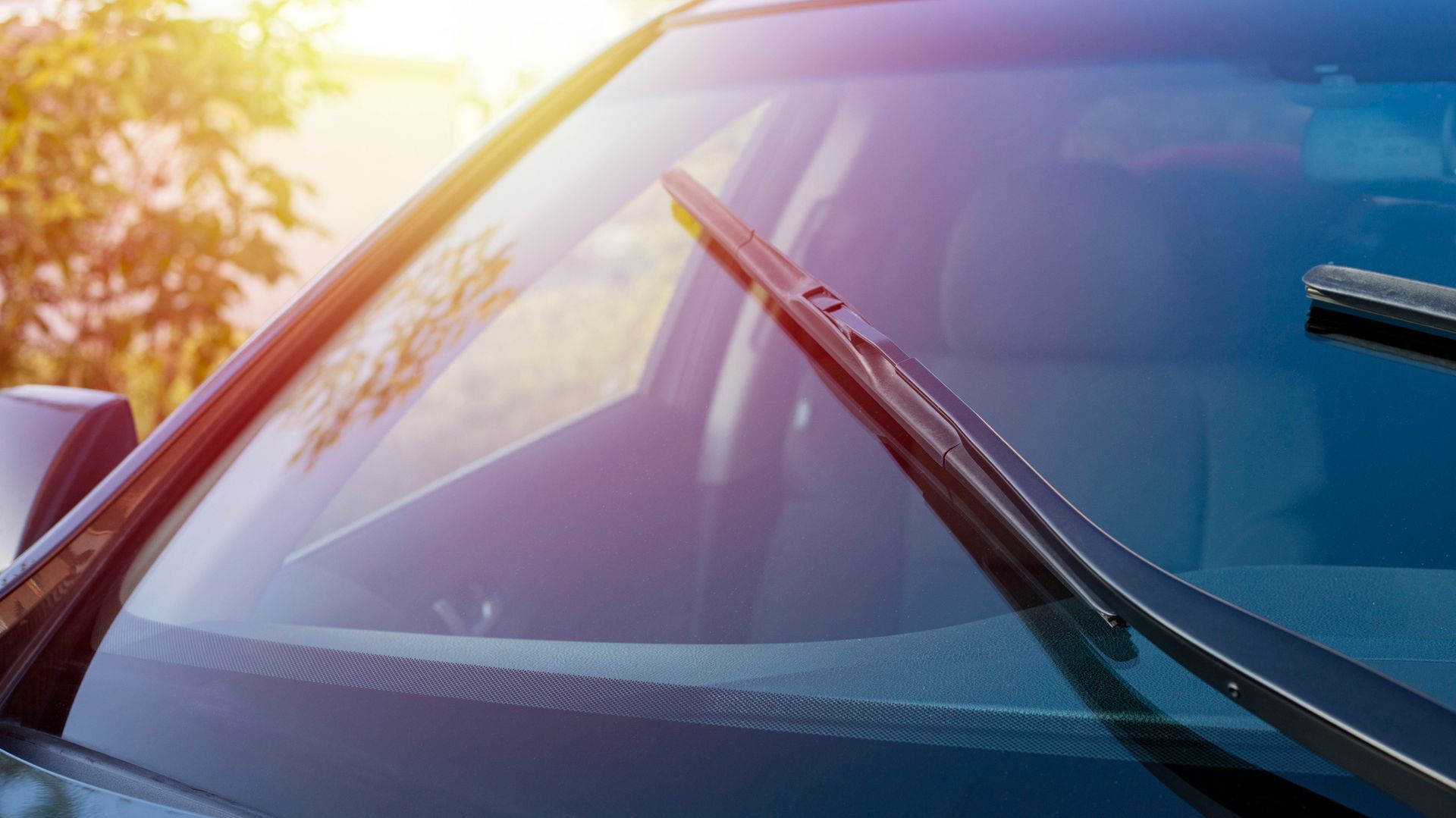 A close up of a car windshield with wiper blades on it.
