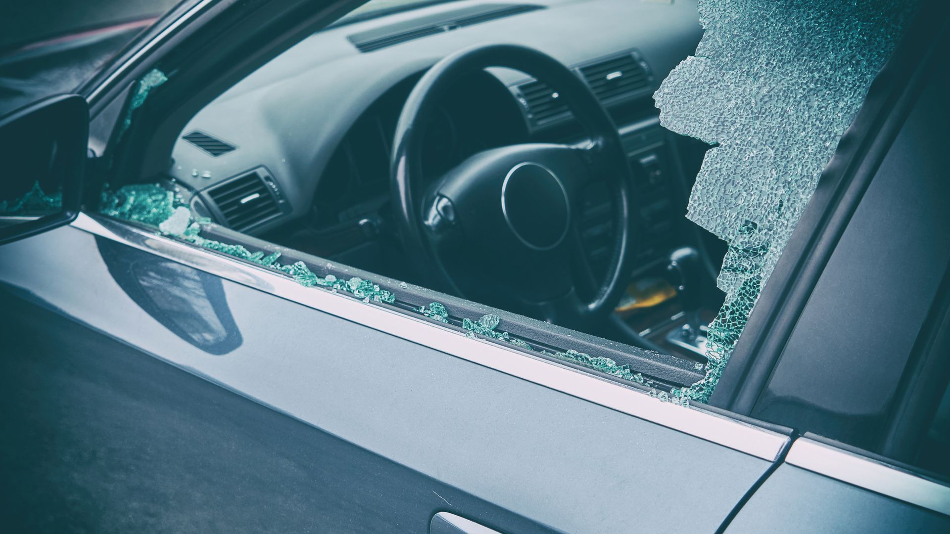 A car with a broken windshield and steering wheel.