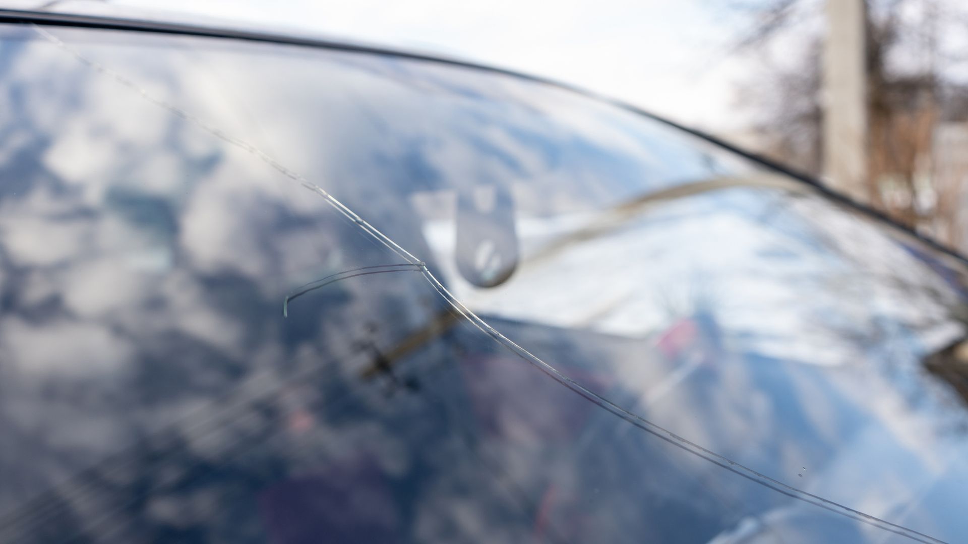A close up of a cracked windshield on a car.
