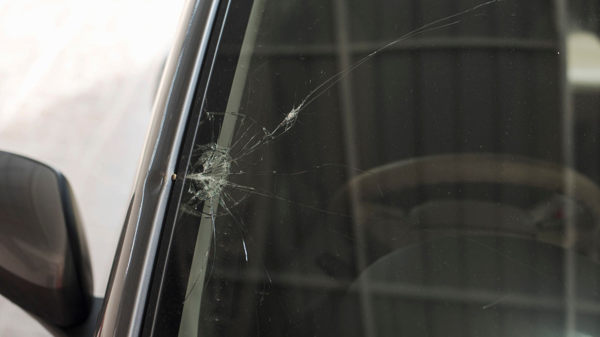 A close up of a broken windshield on a car.