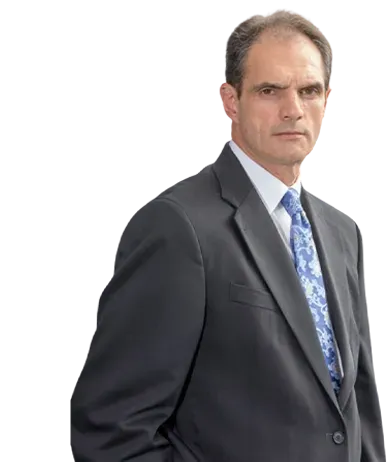 A person in a formal dark suit and blue patterned tie posing against a white background.