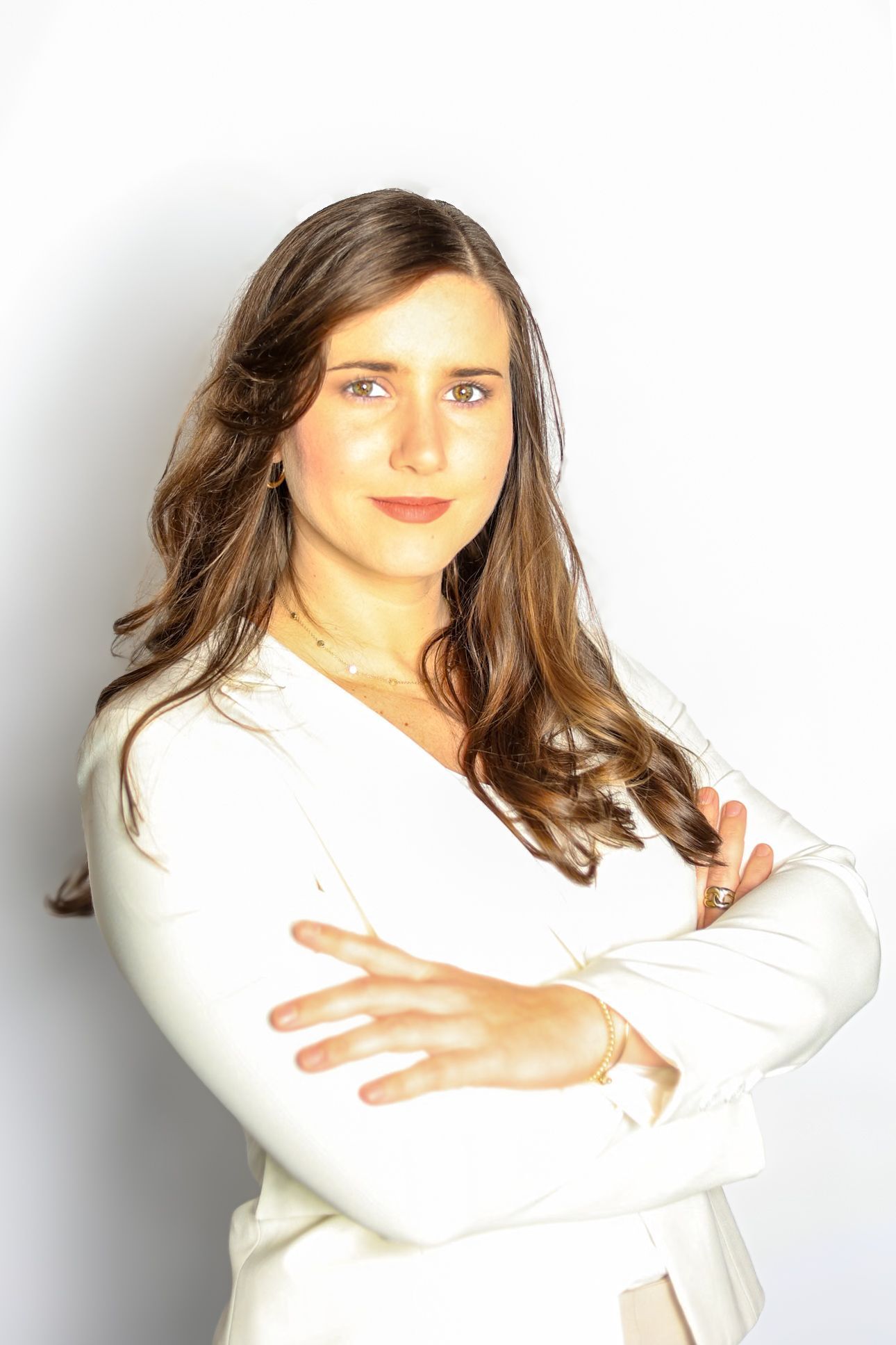 A woman in a white shirt is standing with her arms crossed.