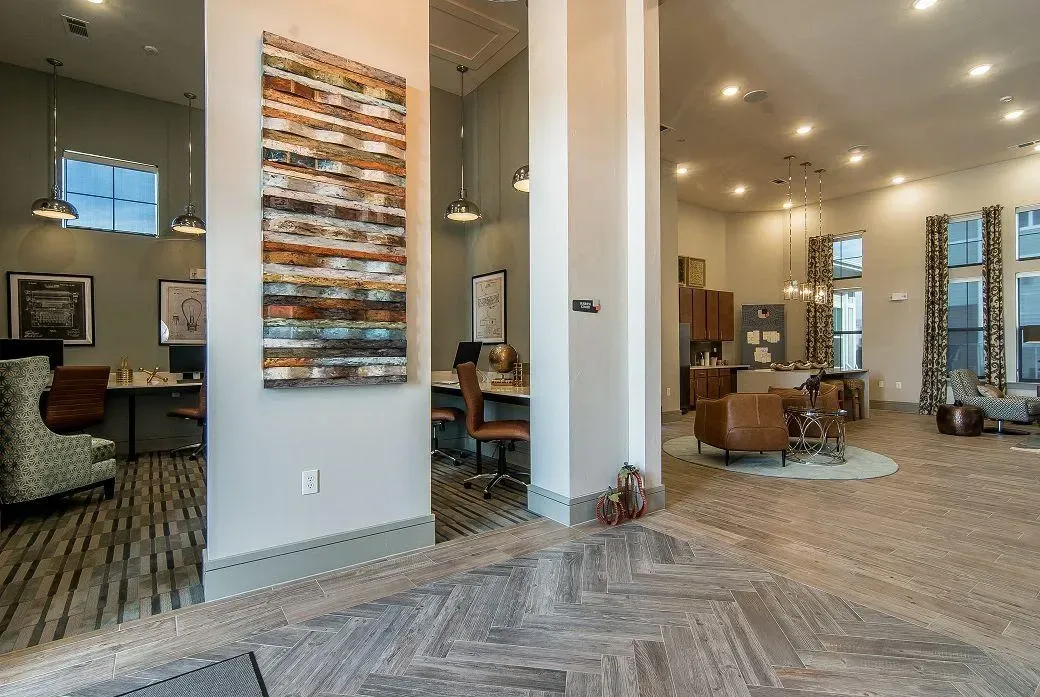 Spacious on-site community lounge with workstations, seating areas, and artwork.