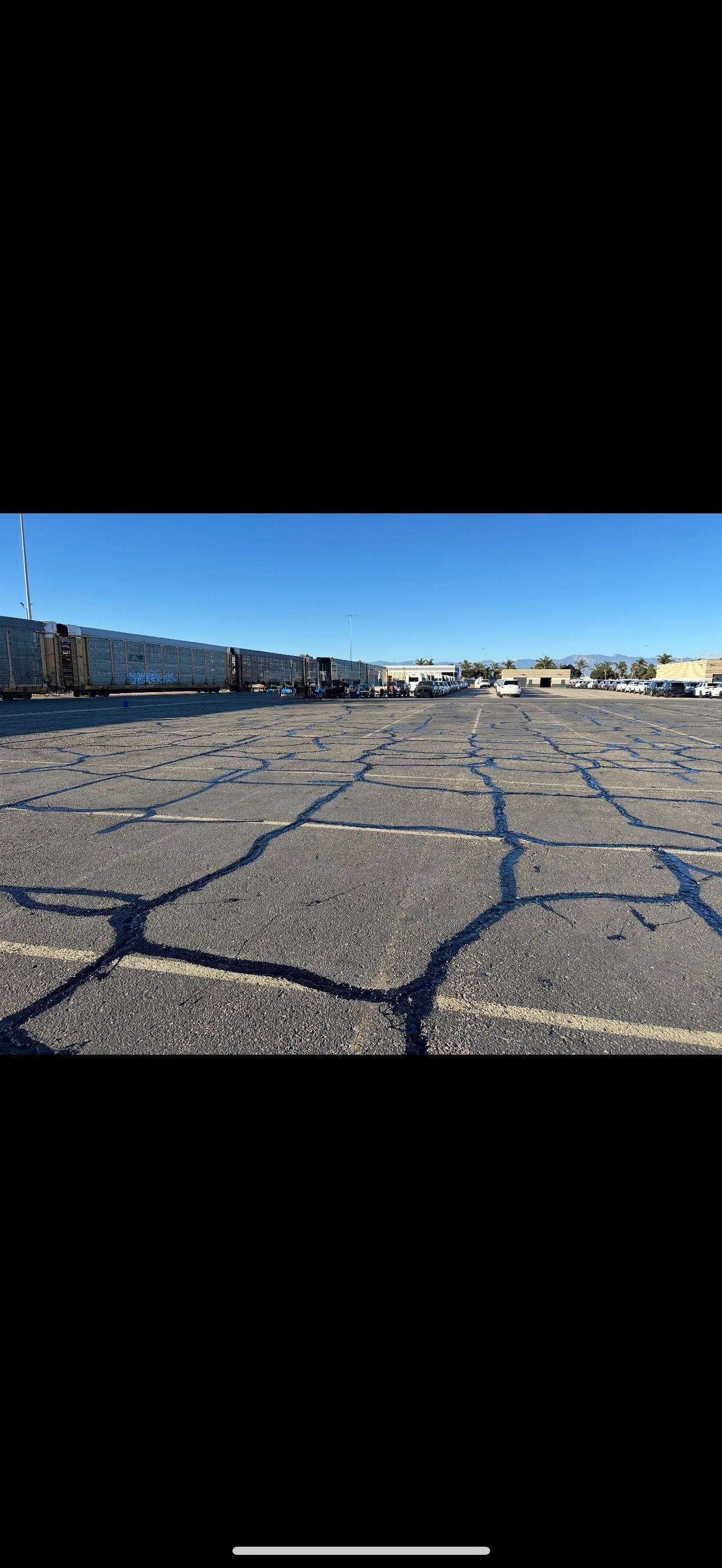 Two designated blue and white wheelchair-accessible parking spaces on black asphalt marked with yellow safety stripes.
