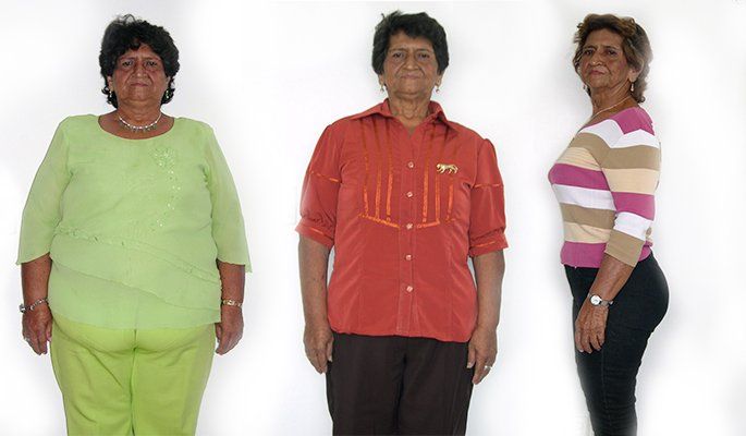 Tres mujeres paradas una al lado de la otra, una de ellas con una camiseta naranja