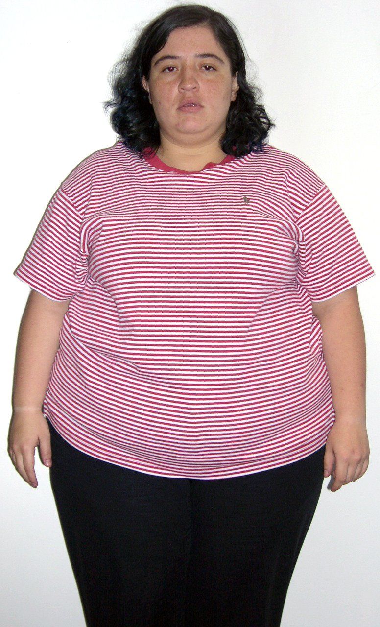 Una mujer lleva una camisa de rayas y pantalones negros.