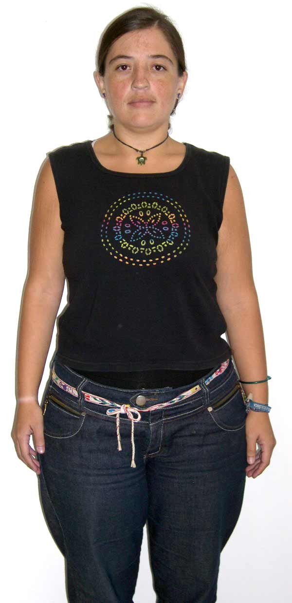 Una mujer que lleva una camiseta negra sin mangas y unos vaqueros azules.