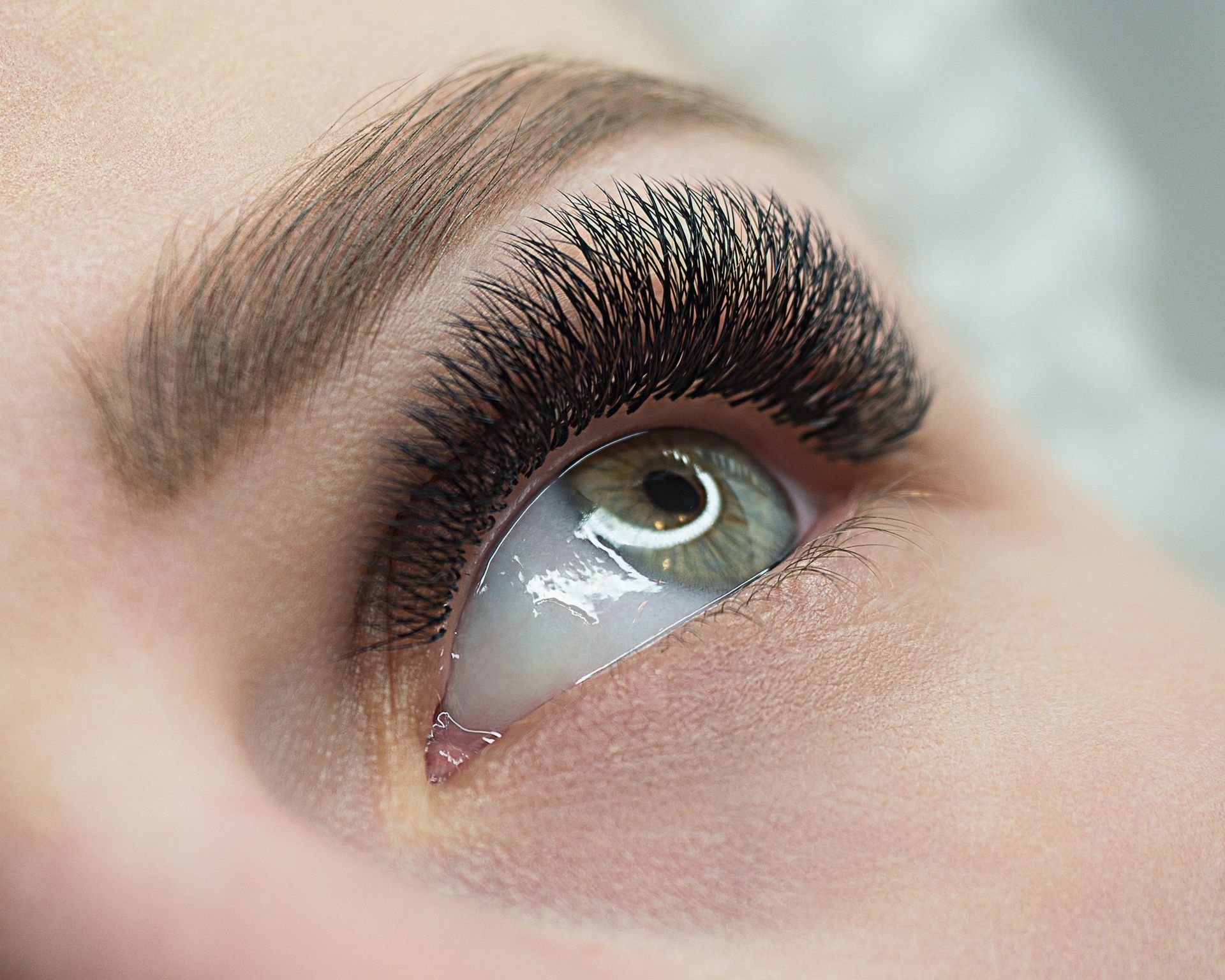 Eine Nahaufnahme des Auges einer Frau mit langen Wimpern.