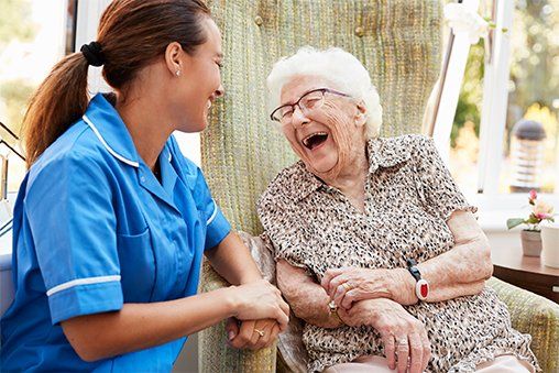 Senior Woman Sitting In Chair And Laughing — Lake Worth, FL — A Visiting Redi-Nurse