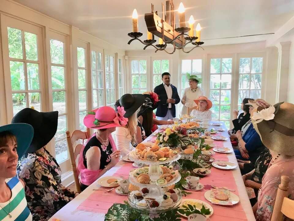 A group of people are sitting at a long table with plates of food.
