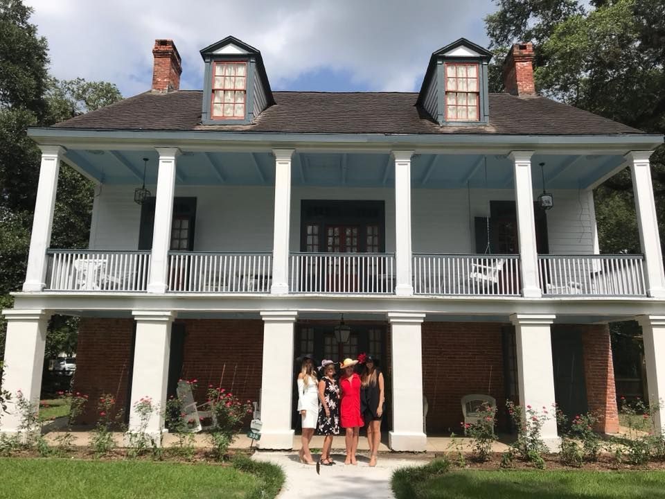 A group of people standing in front of a large white house