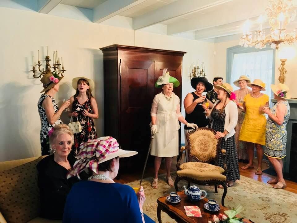 A group of women are standing around a table in a living room.