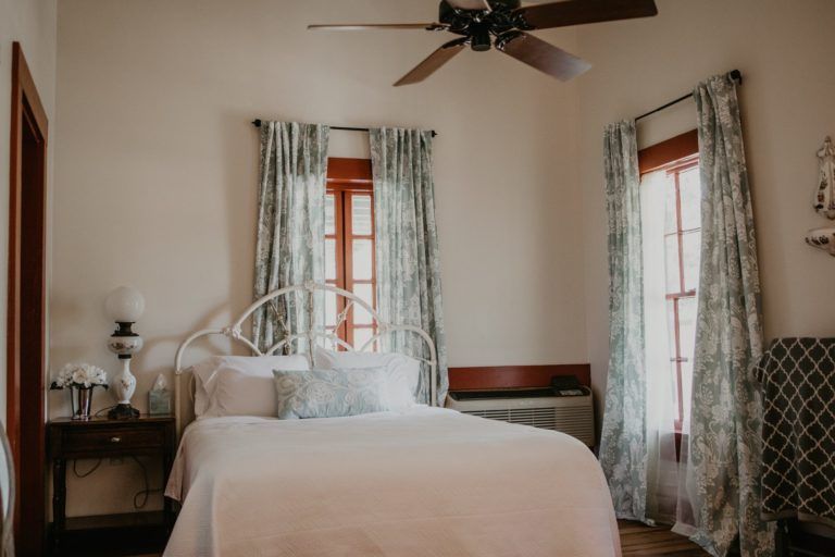 A bedroom with a bed and a ceiling fan.