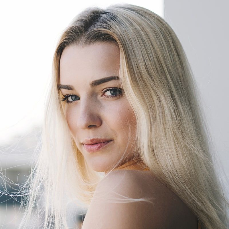 A close up of a woman 's face with long blonde hair.