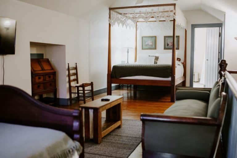 A bedroom with a canopy bed and a couch