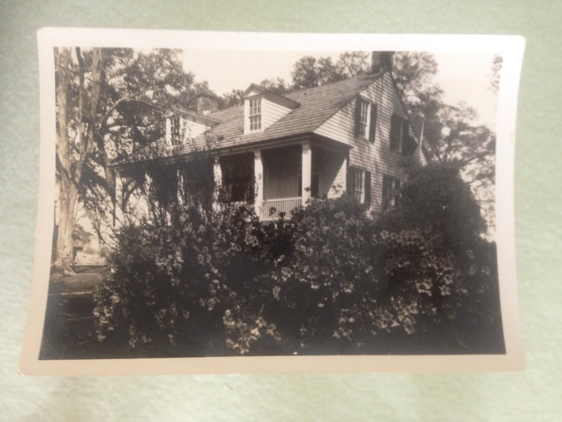 A black and white photo of a house with a porch
