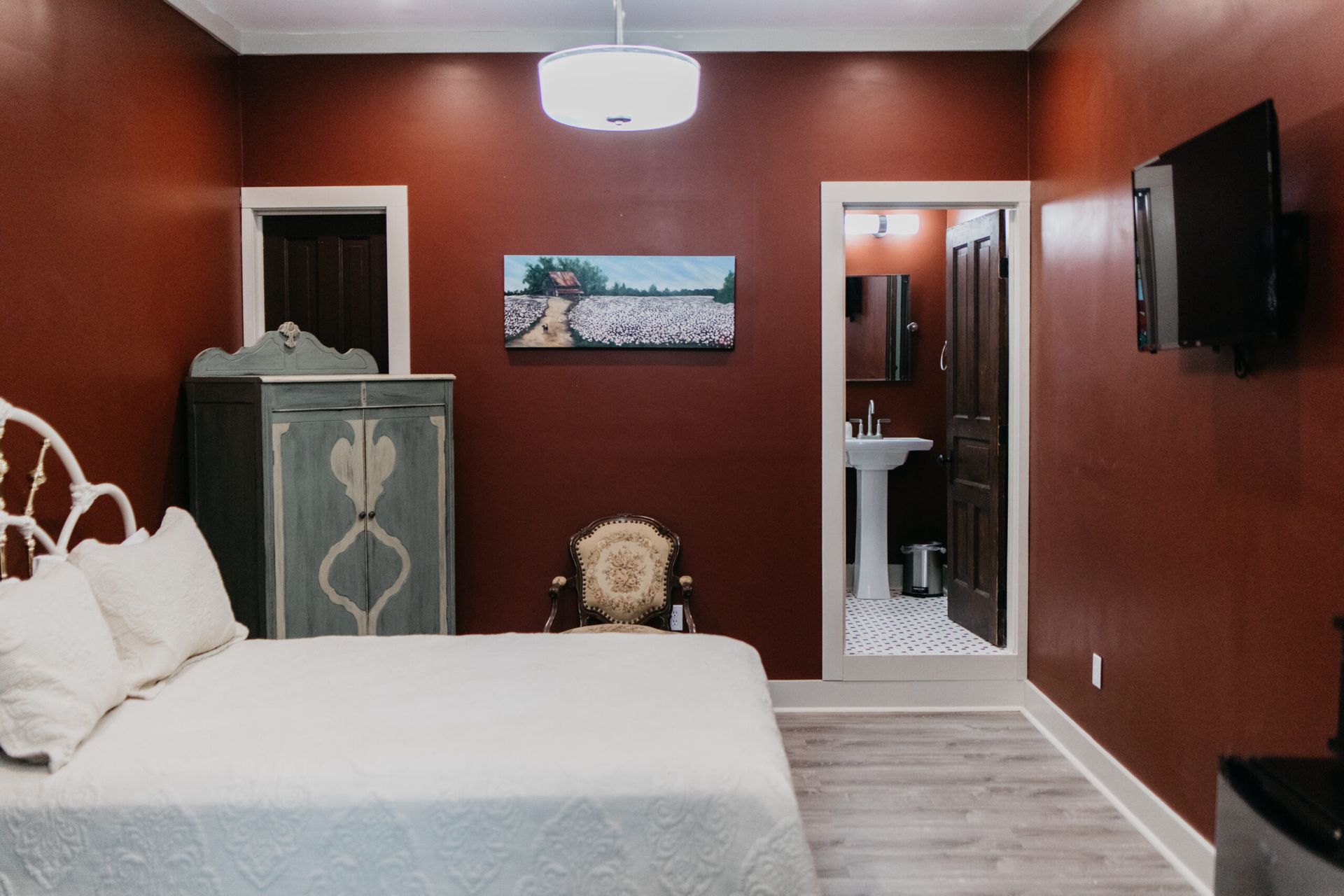 A bedroom with a bed , dresser , chair and television.